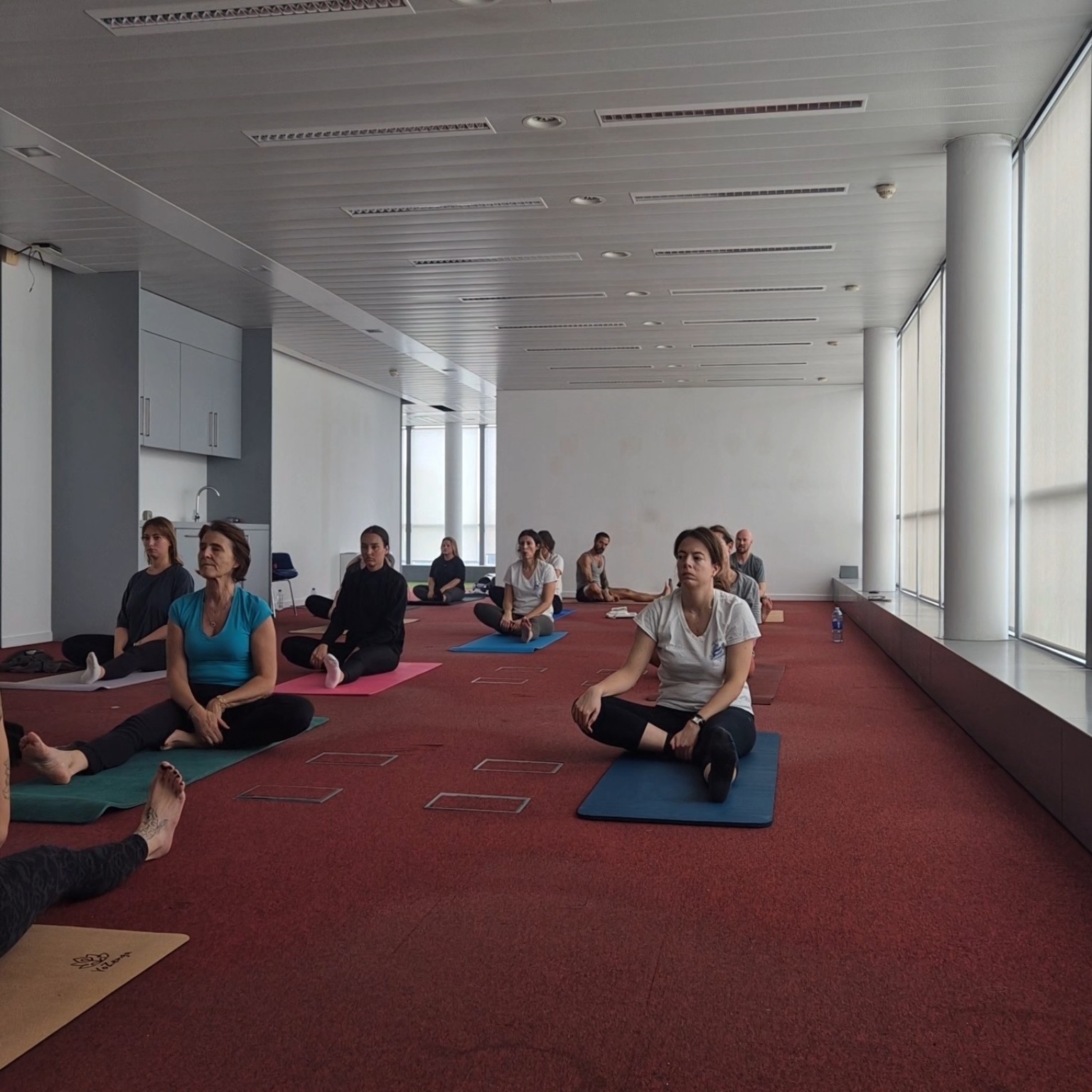 Participants assis en tailleur pendant un temps de respiration guidée au bureau