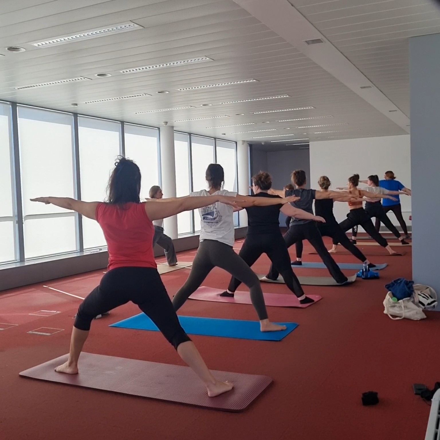 Groupe en posture du guerrier lors d'une séance de yoga au bureau